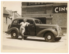 Woman leaning casually against a car.